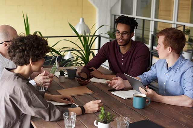 Diverse team having a discussion around a table in a modern office